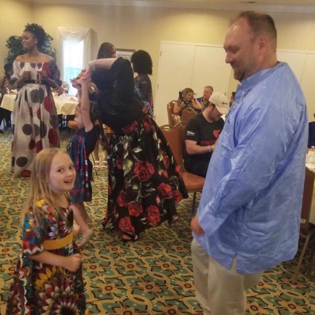 Child dancing with adult at gala