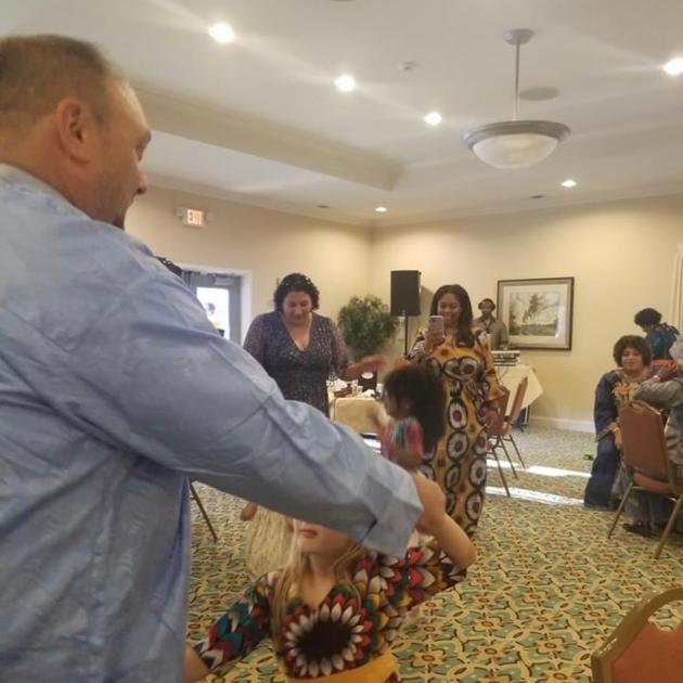Man dancing with child at event